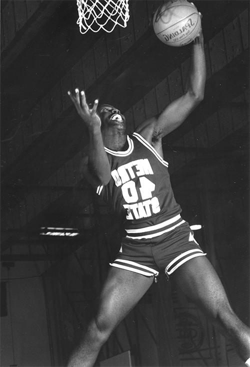 Men's basketball athlete dunking a basketball